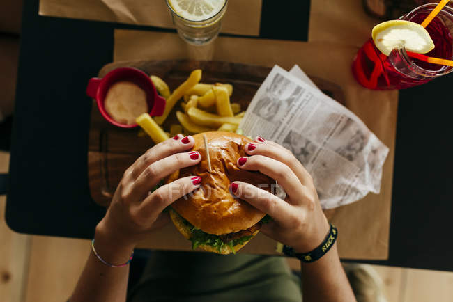 Cultiver les mains féminines cueillette hamburger — Photo de stock