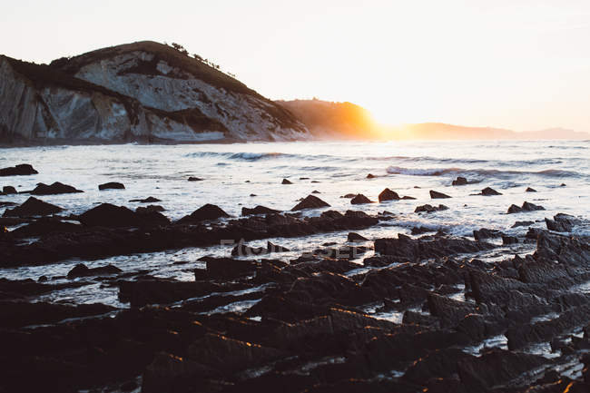 Paisagem panorâmica do pôr do sol na costa rochosa — Fotografia de Stock