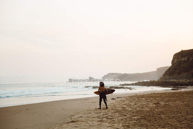 Surfista bambino che cammina al mare con tavola da surf — Foto stock