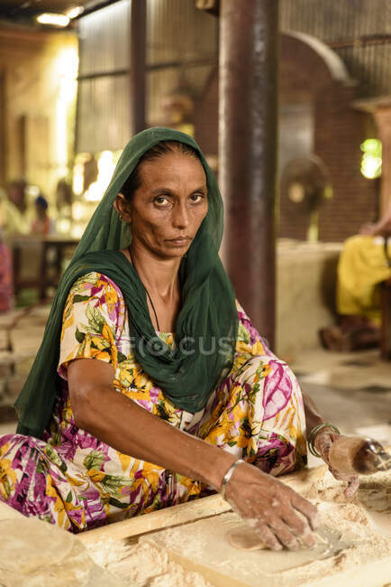 Donna indiana adulta in abiti tradizionali cucina con farina. — Foto stock