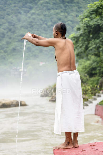 Man doing ritual at river — Stock Photo