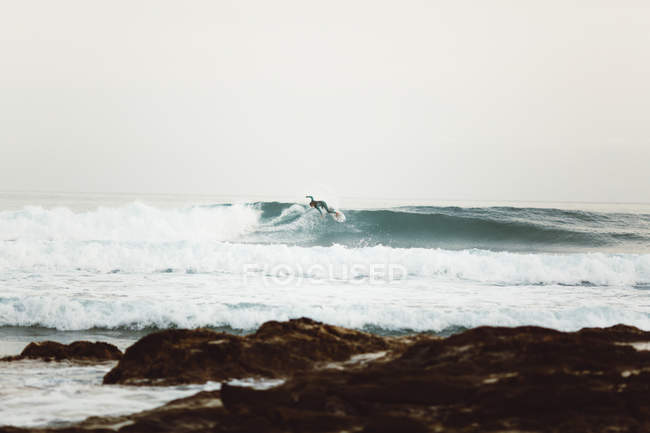 Vue latérale du surfeur attrapant des vagues au bord de la mer — Photo de stock