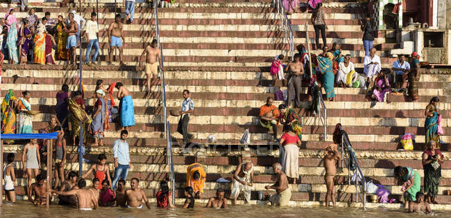 Crowd of Indian people sitting and walking on steps in city. — Stock Photo