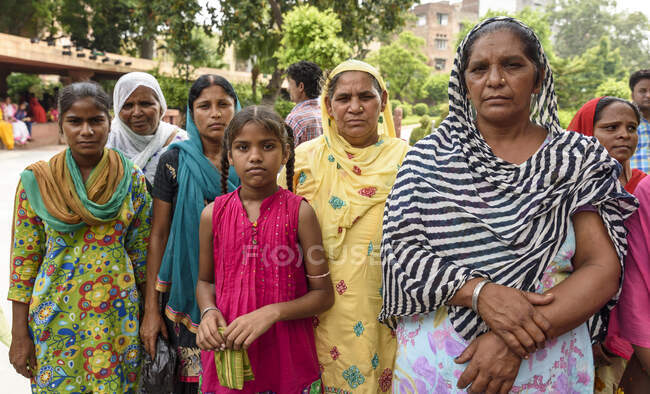 Молодые и взрослые индийские женщины в традиционной одежде стоят на улице. — стоковое фото