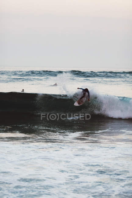 Surfer auf Surfbrett reitet schäumende Welle. — Stockfoto