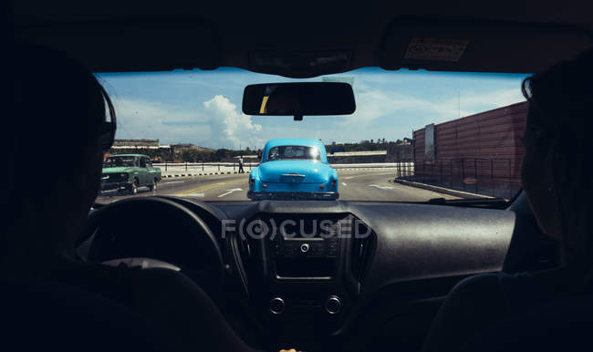 CUBA - 27 AGOSTO 2016: Vista dal sedile posteriore dell'auto d'epoca porta blu sulla strada del traffico nella giornata di sole — Foto stock