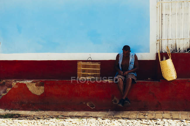 Куби - 27 серпня 2016: Вид спереду людини, сидячи на пошарпаний огорожа на вулиці сцени — стокове фото