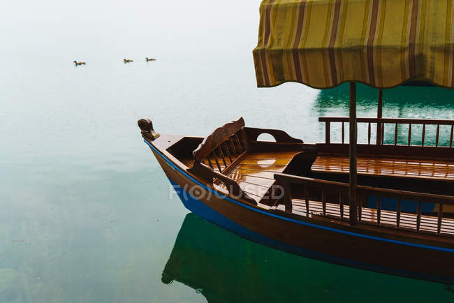 Crop barco vazio com dossel de pano flutuando no lago — Fotografia de Stock