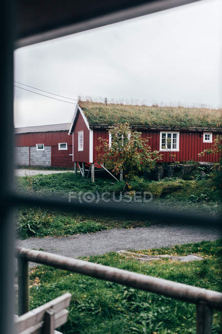 Vista através da janela de casas rurais emcom grama no telhado — Fotografia de Stock
