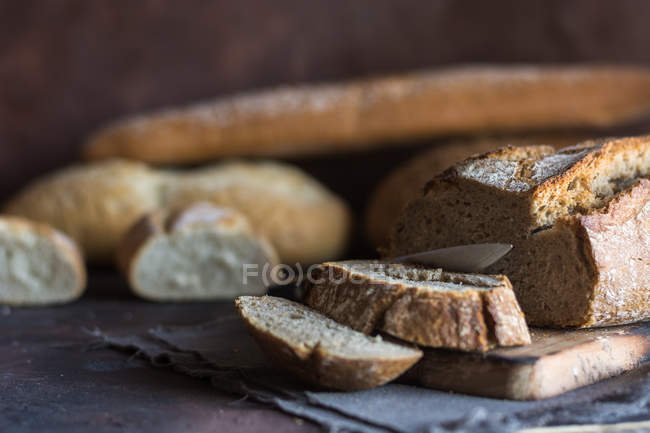Vista de perto de vários pães caseiros na mesa rústica . — Fotografia de Stock