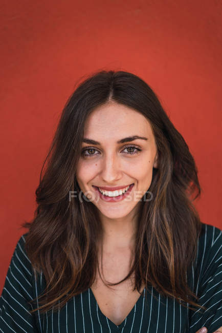 Portrait of smiling pretty woman in formal clothes on red background. — Stock Photo
