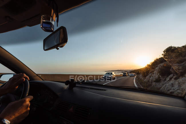 Vue sur la route côtière au coucher du soleil vue depuis le véhicule — Photo de stock