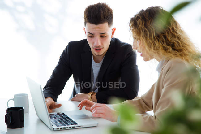 Portrait of business people using laptop in modern office. — Stock Photo