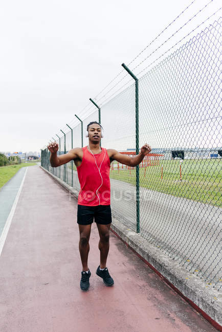 Sportler hören Musik und wärmen Körper vor dem Training auf — Stockfoto