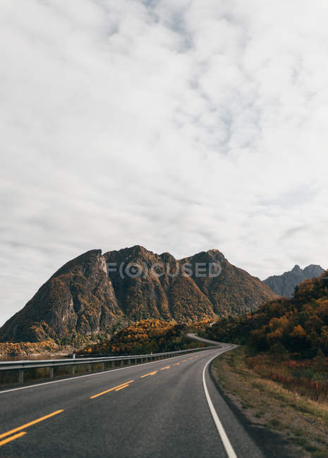 Estrada curvilínea vazia que leva em montanhas — Fotografia de Stock