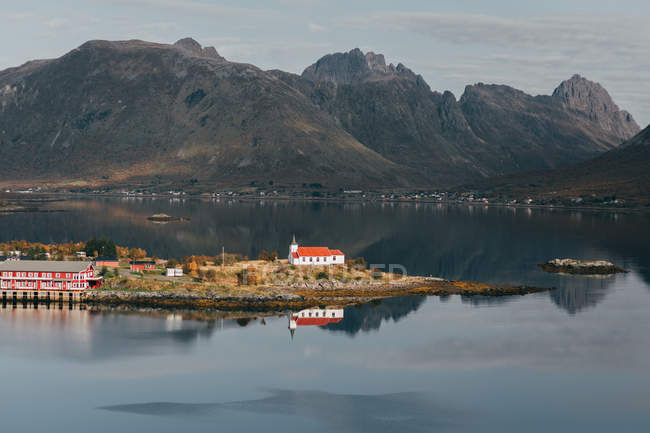 View of island with rural houses amid of mountain lake — Stock Photo