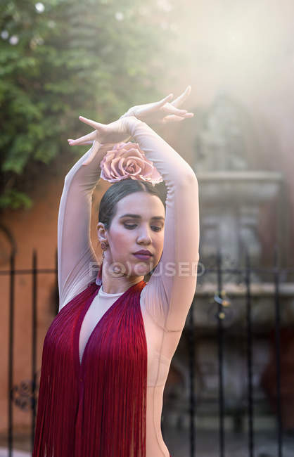 Flamenco dancer posing in red dress at sunlit streets — Stock Photo