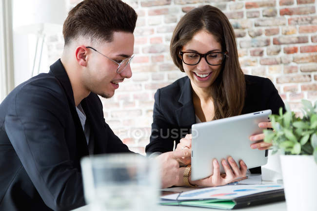 Portrait of business people using tablet in modern office. — Stock Photo