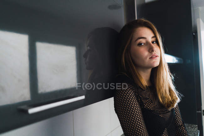 Sensual brunette girl posing at kitchen and looking at camera — Stock Photo