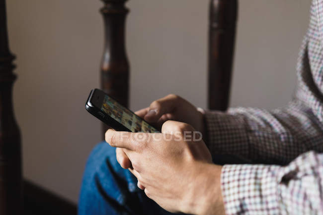 Crop male hands chatting on smartphone at staircase — Stock Photo
