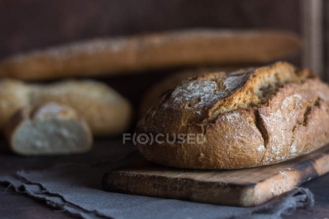 Vista a nivel de superficie de los panes caseros sobre una mesa rústica . - foto de stock
