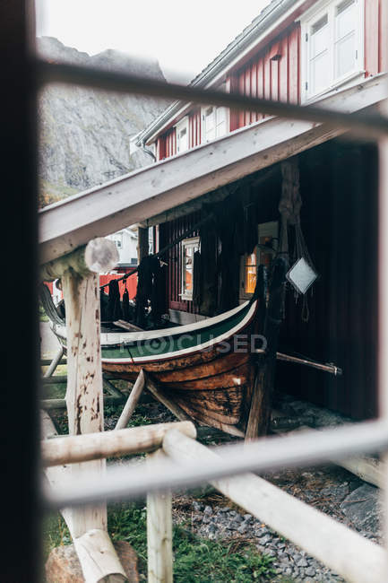 View from window of old shabby boat standing under roof besider ed house — Stock Photo