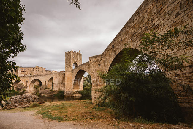 View of medieval bridge stone pylons over cloudy sky — Stock Photo