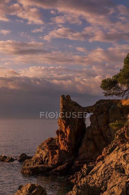 Paysage nuageux au coucher du soleil vu de la côte rocheuse — Photo de stock