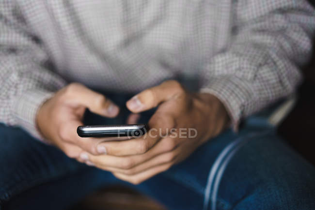 Mid section of man chatting on smartphone — Stock Photo