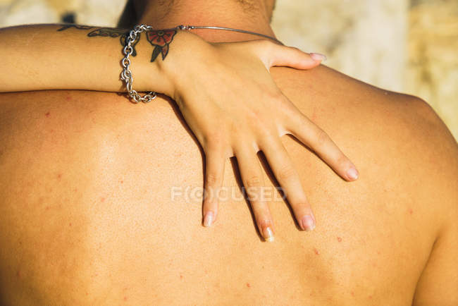 Close up de mão tatuada feminina em homens sem camisa de volta — Fotografia de Stock