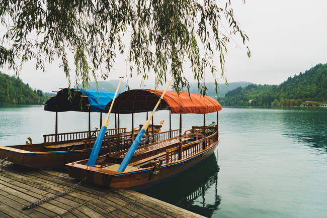 Bateaux amarrés vides avec verrière en tissu sur le lac — Photo de stock