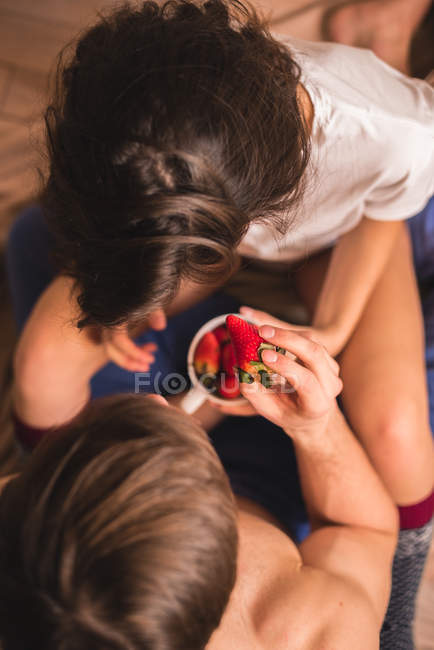 Vista desde arriba a la pareja sosteniendo taza de fresa . - foto de stock