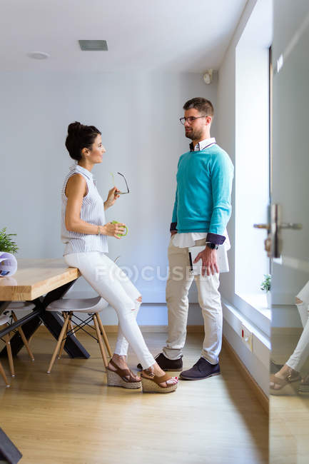 Portrait of business people standing in modern office and chatting — Stock Photo