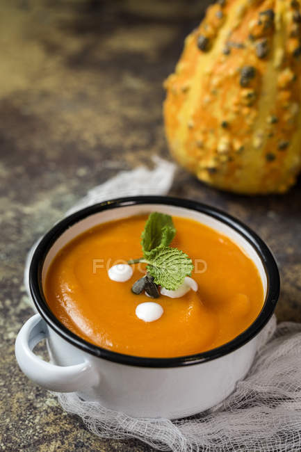 Close up view of cream of pumpkin in saucepot on white gauze — Stock Photo