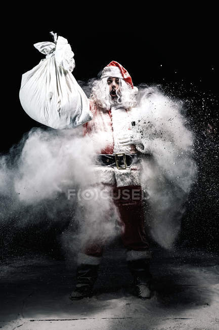 Santa Claus in center of snow explosion — Stock Photo