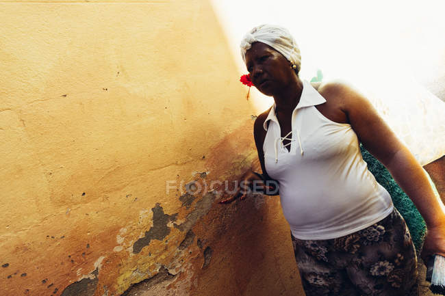 Kuba - 27. August 2016: Porträt einer Frau, die an einer Straße mit verwitterter Wand steht — Stockfoto