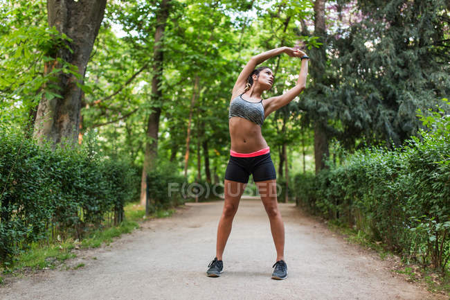 Girl stretching up back on park alley on sunny day — Stock Photo