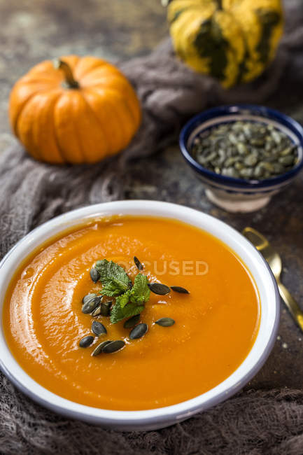 Close up view of cream of pumpkin with seeds in bowl — Stock Photo