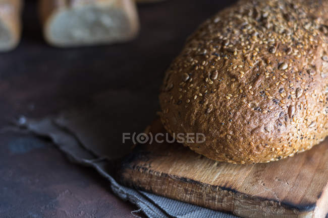 Close up of home-made bread loaf on wooden board. — Stock Photo