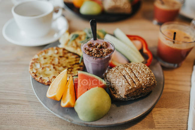 Vue rapprochée de la plaque avec des aliments sains sur une table en bois — Photo de stock