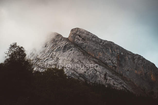 Picturesque view of mountain over misty cloud — Stock Photo