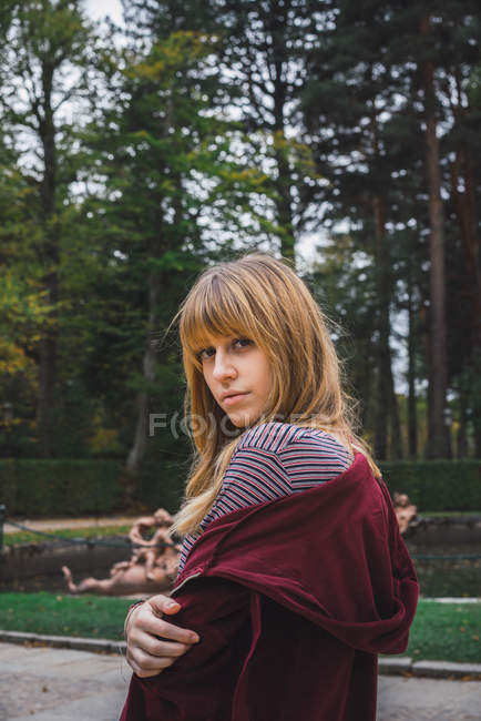 Ritratto di ragazza bruna con cappuccio rosso che guarda oltre la spalla alla macchina fotografica — Foto stock