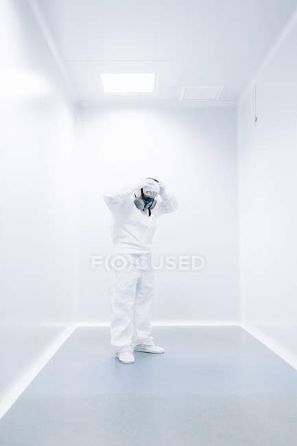 Científico poniéndose máscara protectora en laboratorio - foto de stock