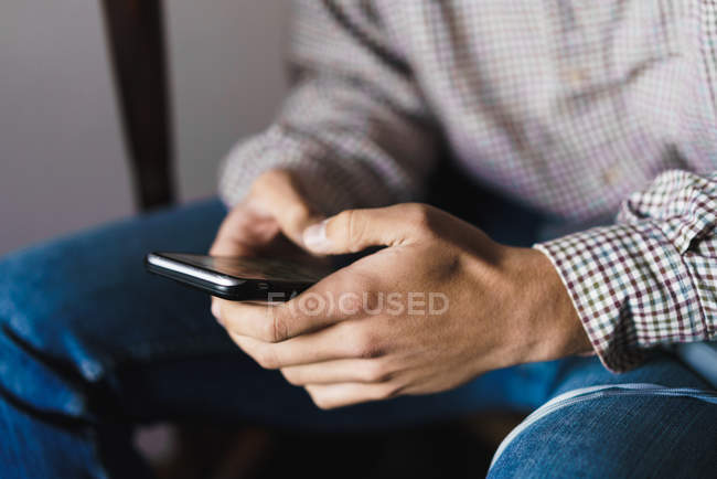 Crop male hands with smartphone on staircase — Stock Photo
