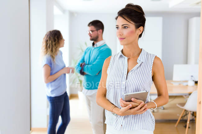 Portrait of businesswoman posing at camera and looking sideways in modern office. — Stock Photo