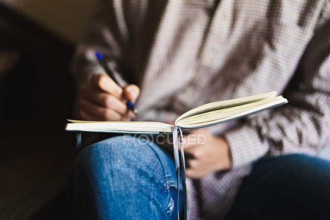 Erntehelfer schreibt mit Stift in Notizbuch — Stockfoto