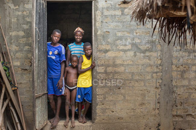 BENIN, AFRICA - 31 AGOSTO 2017: Famiglia africana in piedi davanti alla porta e davanti alla telecamera — Foto stock