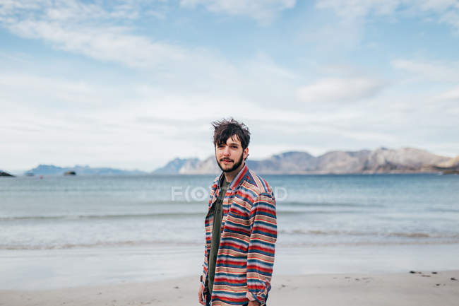 Портрет людини, що позує на березі гірського озера і дивиться на камеру — стокове фото