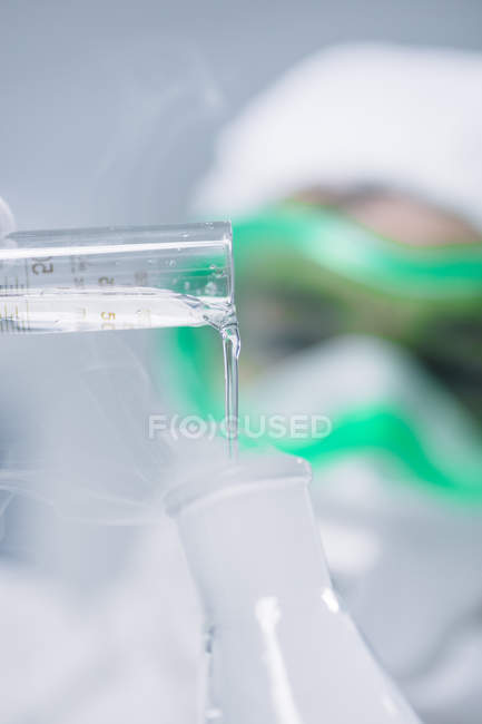 Immagine tagliata scienziato aggiungendo liquido in fiaschetta — Foto stock