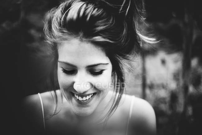 Retrato de una chica sonriente mirando hacia abajo - foto de stock